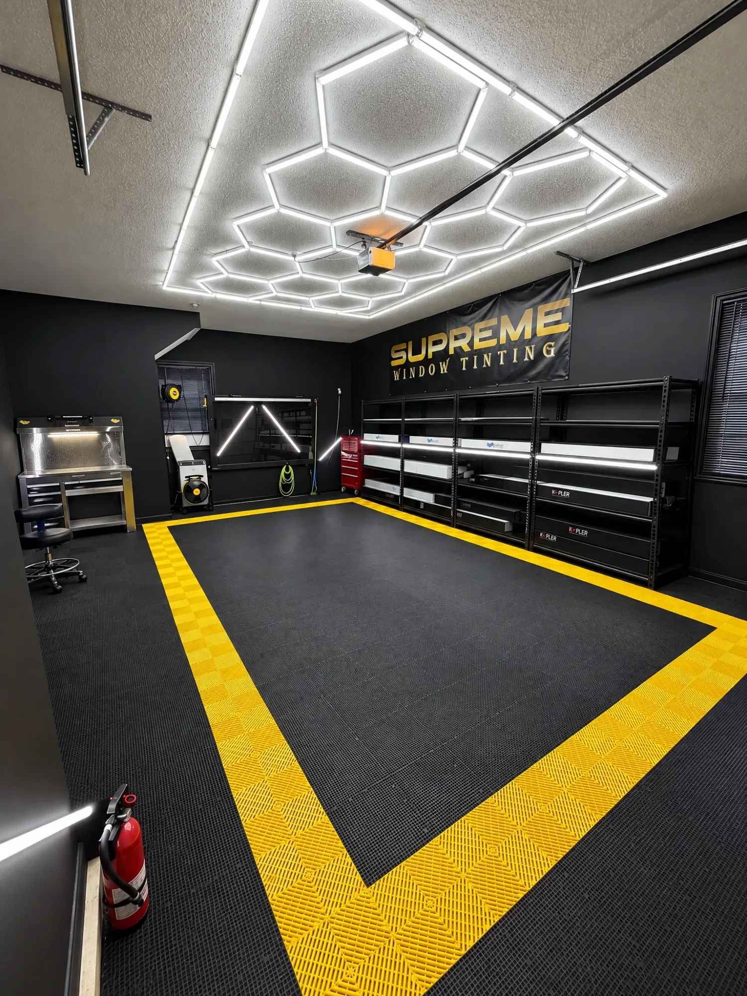 Inside the Supreme Window Tinting studio: the yellow floor border, the honeycomb lights and the shelving wall